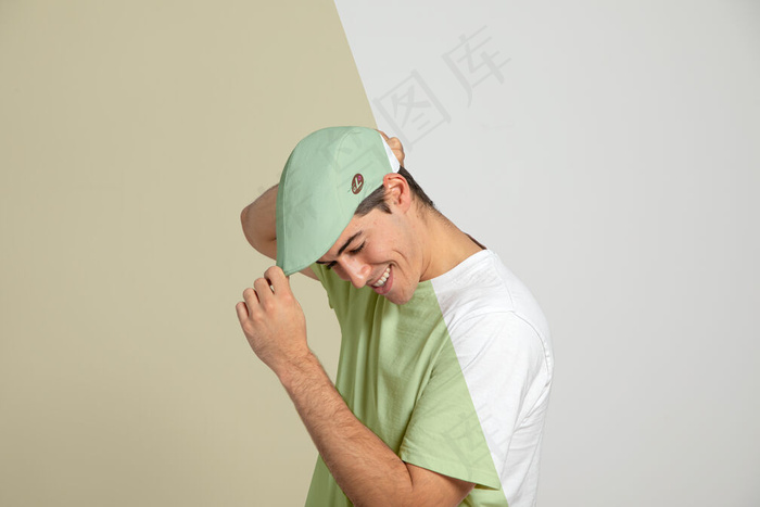 男人摸帽子的侧视图
