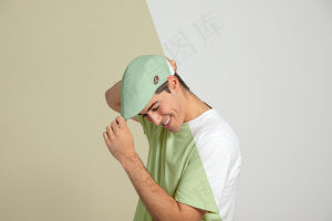 男人摸帽子的侧视图