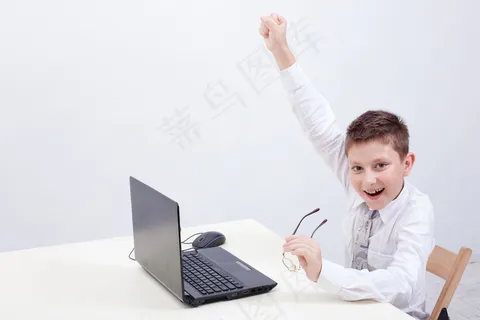 男孩在用他的笔记本电脑 男孩在用他的笔记本电脑