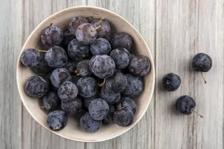 木制背景上碗上的酸蓝色黑色小树懒的俯视图
