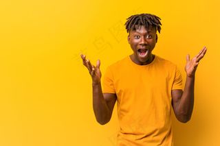 年轻的黑人男子，身穿黄袍，庆祝胜利或成功