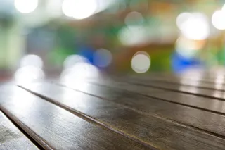 老式古色古香的棕色木质桌面，带有模糊的餐厅酒吧咖啡厅浅色b背景：邋遢的老年人带有模糊暖奶油色背景的木头