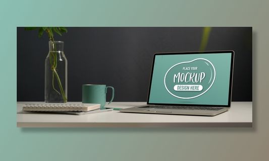 家庭办公室白色办公桌上的笔记本电脑、文具、植物花瓶和马克杯的特写镜头