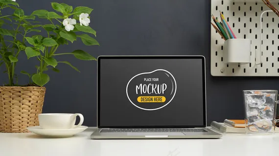 工作台上的模拟笔记本电脑的特写视图，工作区内有咖啡杯和装饰品
