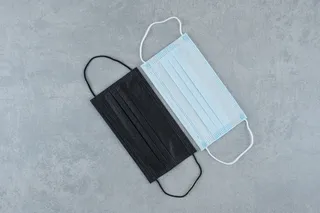 灰色背景上的两个防护医用口罩。高品质照片