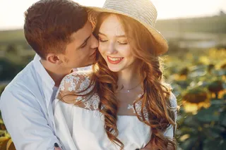 美丽时尚的情侣在向日葵丛中