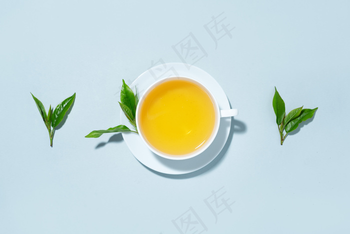 在蓝色粉彩背景上用茶叶泡成的绿茶。俯视图。