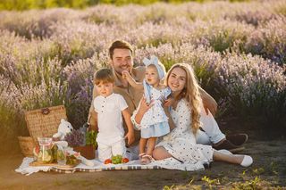 一家人在薰衣草地上。野餐的人。有孩子的母亲吃水果。