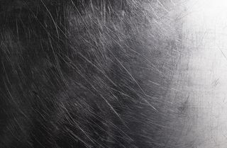 旧的闪亮金属背景，深色拉丝金属纹理有划痕