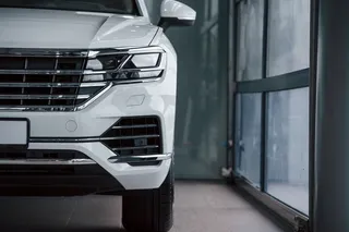 鲜艳的颜色。白天停放在室内的现代豪华白色轿车的粒子视图