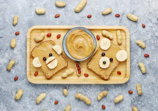 有趣的熊和猴脸三明治花生酱，香蕉和黑醋栗，花生，俯视图