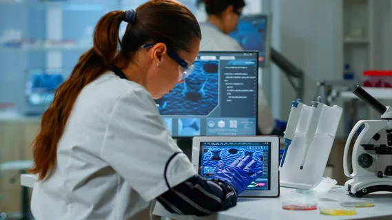 科学家使用数字平板电脑在现代医学研究实验室工作,分析 dna 信息。医学、先进制药实验室的生物技术研究、病毒进化研究 科学家使用数字平板电脑在现代医学研究实验室工作,分析 dna 信息。医学、先进制药实验室的生物技术研究、病毒进化研究