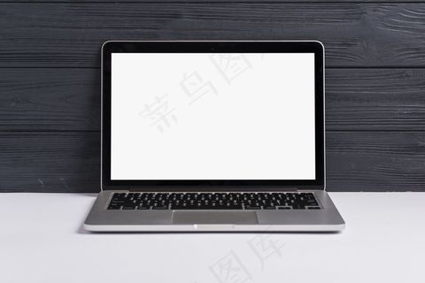 一台打开的笔记本电脑，白色桌面上有一个黑色的木质背景