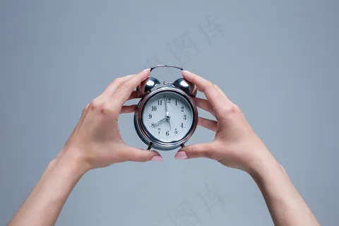手持老式闹钟的女性手 手持老式闹钟的女性手