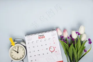 日历和时钟旁的郁金香俯视图