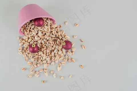 装满健康麦片和圣诞球的粉红色桶。 装满健康麦片和圣诞球的粉红色桶。