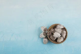 蓝色空间的木制碟子里的干李子枣