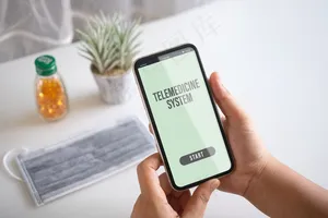 模拟手机，一个人拿着智能手机和面罩，桌上放着医用平板电脑进行远程医疗
