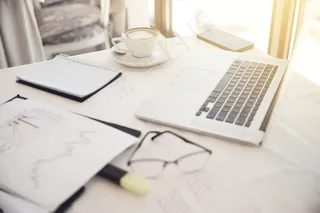 工作场所物体前景：眼镜、图表、笔记本电脑、笔记本电脑