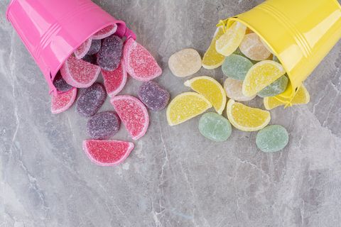 黄色和粉色的桶，大理石背景上有糖果酱。