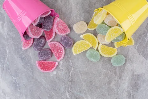 黄色和粉色的桶，大理石背景上有糖果酱。