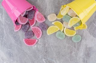 黄色和粉色的桶，大理石背景上有糖果酱。