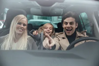 兴高采烈的男人和妻子女儿坐在车里