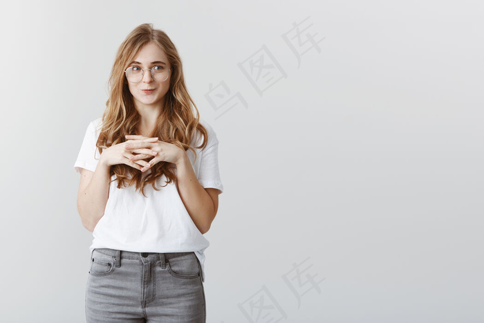 迷人的金发女孩微笑着看着左边的渴望和喜悦