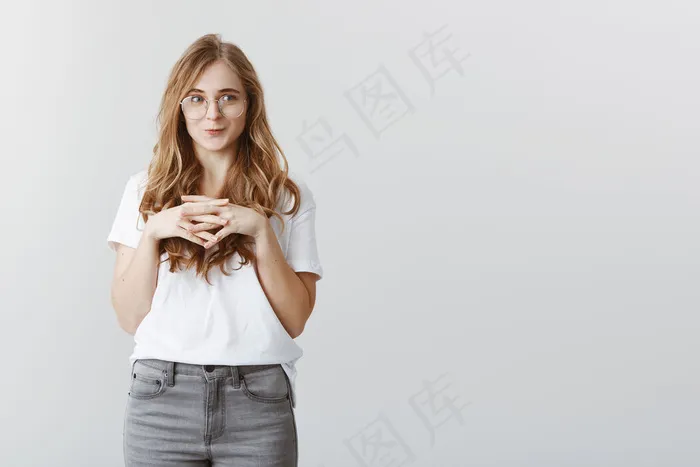 迷人的金发女孩微笑着看着左边的渴望和喜悦