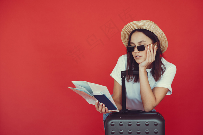 红墙上摆着旅游设备的时髦女孩