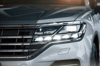 对于成功人士。白天停放在室内的现代豪华白色轿车的粒子视图