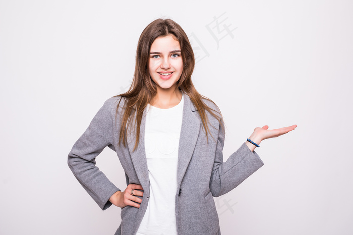 惊讶的女士在白色背景上展示打开的手掌和产品或文本的复制空间