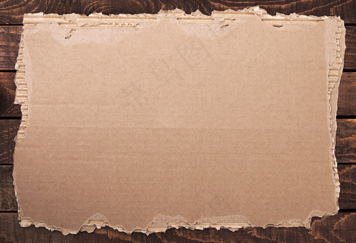 撕破的纸。木质纹理上的纸板破损。