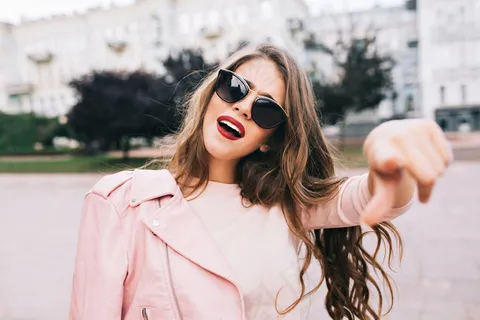 一个戴着太阳镜的长发女孩的特写镜头在城市里。