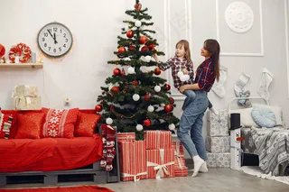 妈妈带着可爱的女儿在家拿着圣诞礼物