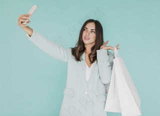 拎着购物袋自拍的年轻女子