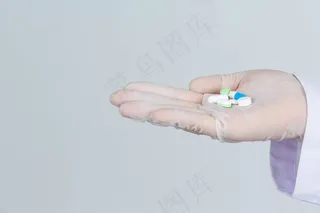 年轻漂亮的医生戴着口罩，手里拿着药，灰色的墙上戴着橡胶手套。