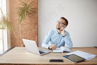 成熟开朗的男经理在笔记本上工作，在笔记本上记下信息，