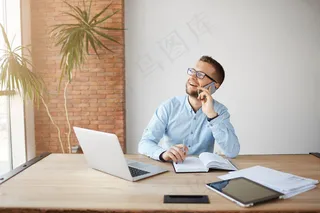 成熟开朗的男经理在笔记本上工作，在笔记本上记下信息，