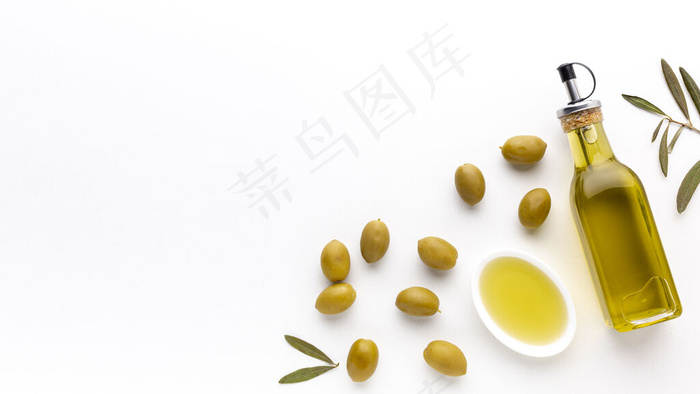 高角度橄榄油瓶和碟子与黄橄榄和复制空间