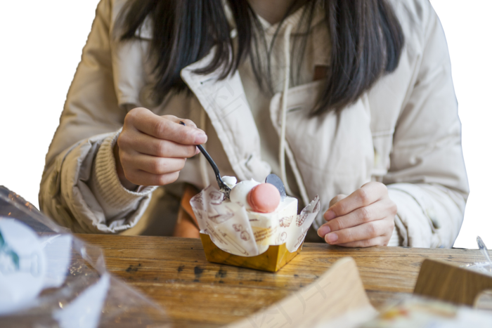 一个穿棉服的女孩在吃蛋糕