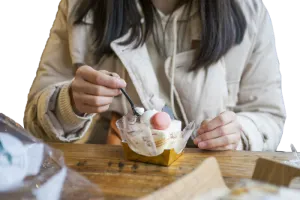 一个穿棉服的女孩在吃蛋糕