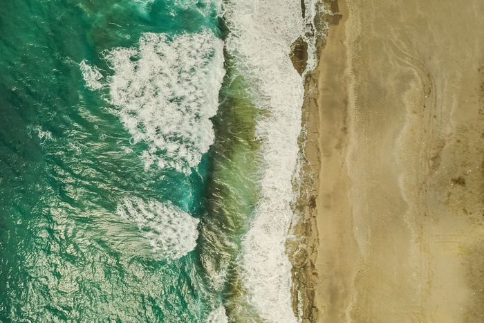 沙与海水和海浪相遇的鸟瞰图