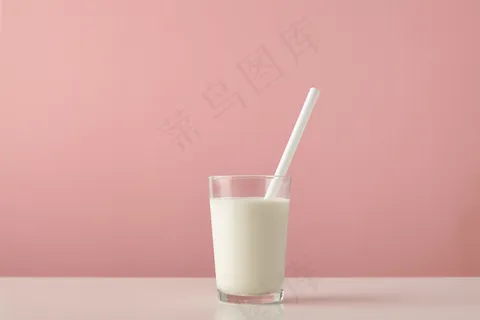 透明玻璃,内有新鲜的有机牛奶和白色吸管,木质桌子上的粉色背景将其隔离 透明玻璃,内有新鲜的有机牛奶和白色吸管,木质桌子上的粉色背景将其隔离