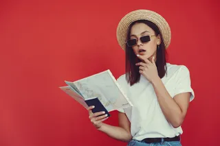 红墙上摆着旅游设备的时髦女孩