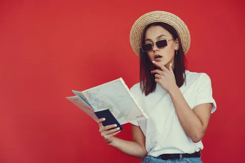 红墙上摆着旅游设备的时髦女孩 红墙上摆着旅游设备的时髦女孩
