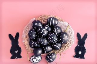 复活节彩蛋和复活节兔子放在粉红色的桌子上