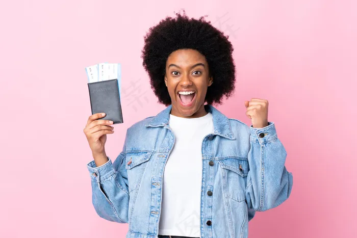 年轻的非洲裔美国妇女被隔离在粉红色的墙上，带着护照和机票在度假