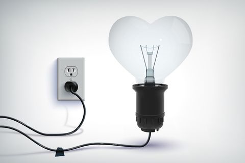 现实的浪漫概念的现实有线灯泡在心形与插头隔离
