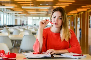 在大学图书馆学习的年轻学生的肖像。教育和生活方式理念。